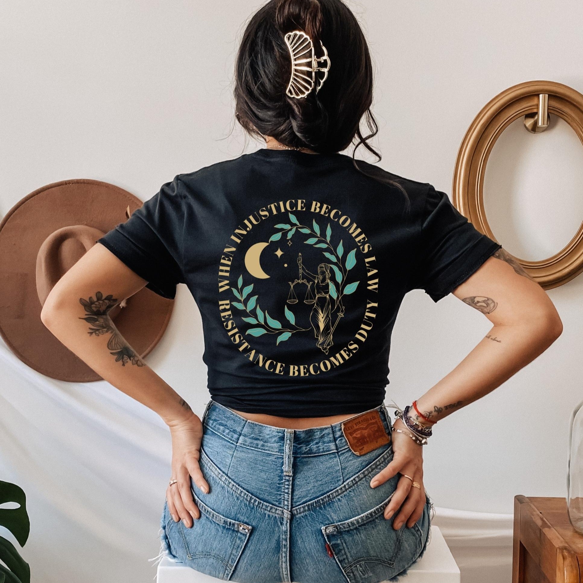 Model wearing a black t shirt that reads when injustice becomes law resistance becomes duty