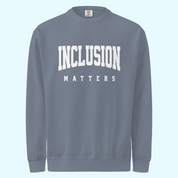 Solo mockup of the “Inclusion Matters” sweatshirt in a faded blue jean Comfort Colors style. The sweatshirt features bold white text centered on the chest, with a relaxed, cozy fit and vintage-washed look displayed against a neutral background.