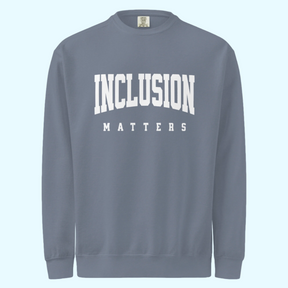 Solo mockup of the “Inclusion Matters” sweatshirt in a faded blue jean Comfort Colors style. The sweatshirt features bold white text centered on the chest, with a relaxed, cozy fit and vintage-washed look displayed against a neutral background.