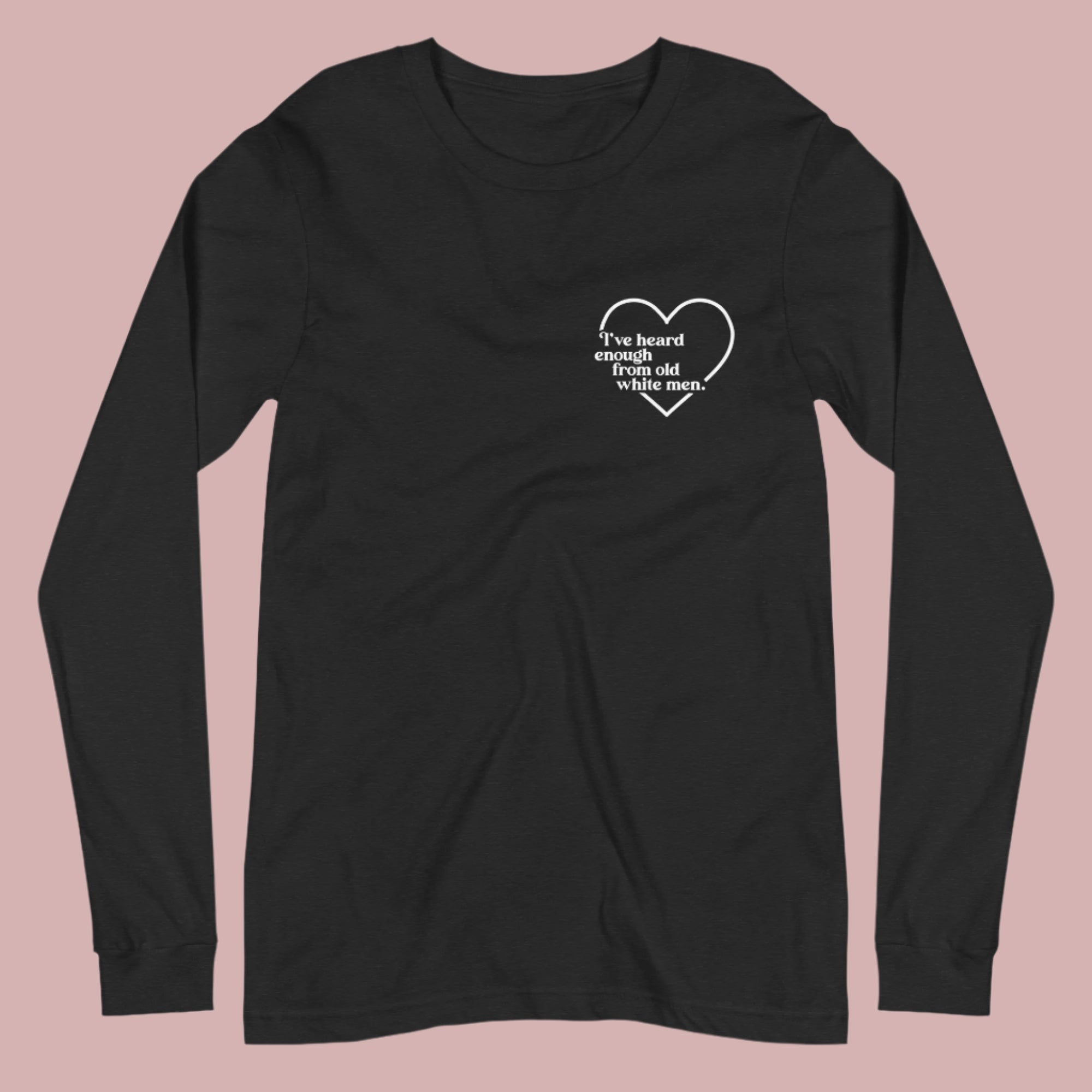 Flat lay of a black long-sleeved t-shirt on a white background. A small white heart in the upper left chest area surrounds the text: “I’ve heard enough from old white men.”