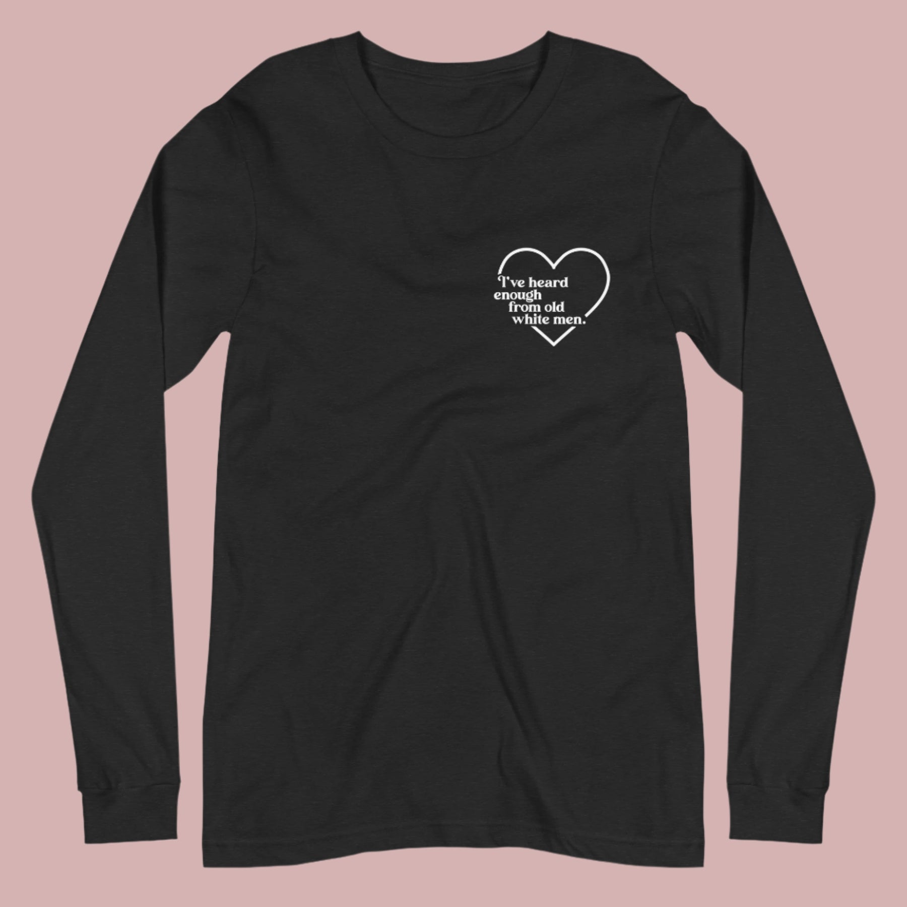 Flat lay of a black long-sleeved t-shirt on a white background. A small white heart in the upper left chest area surrounds the text: “I’ve heard enough from old white men.”