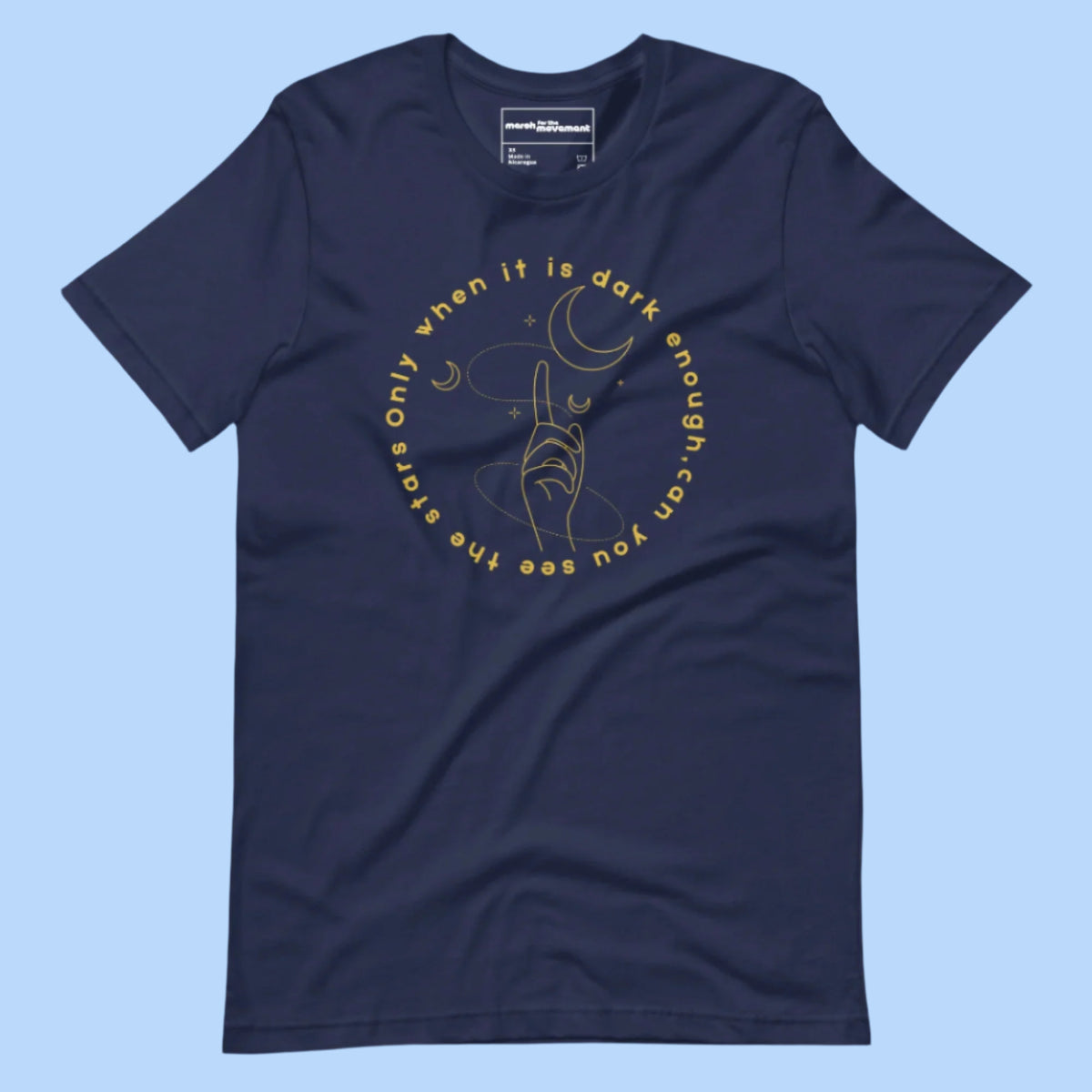 Flat lay of a T-shirt with the quote 'Only when it is dark enough can you see the stars' printed across the front.