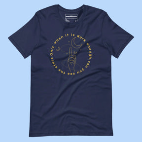 Flat lay of a T-shirt with the quote 'Only when it is dark enough can you see the stars' printed across the front.