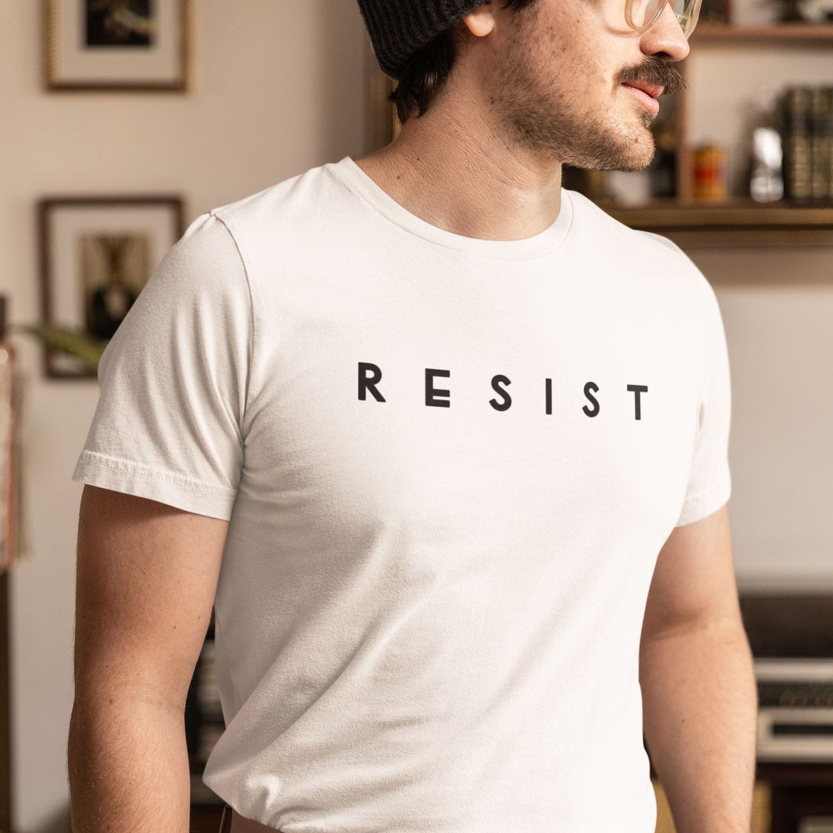 Photo of a man wearing a white t shirt that says resist