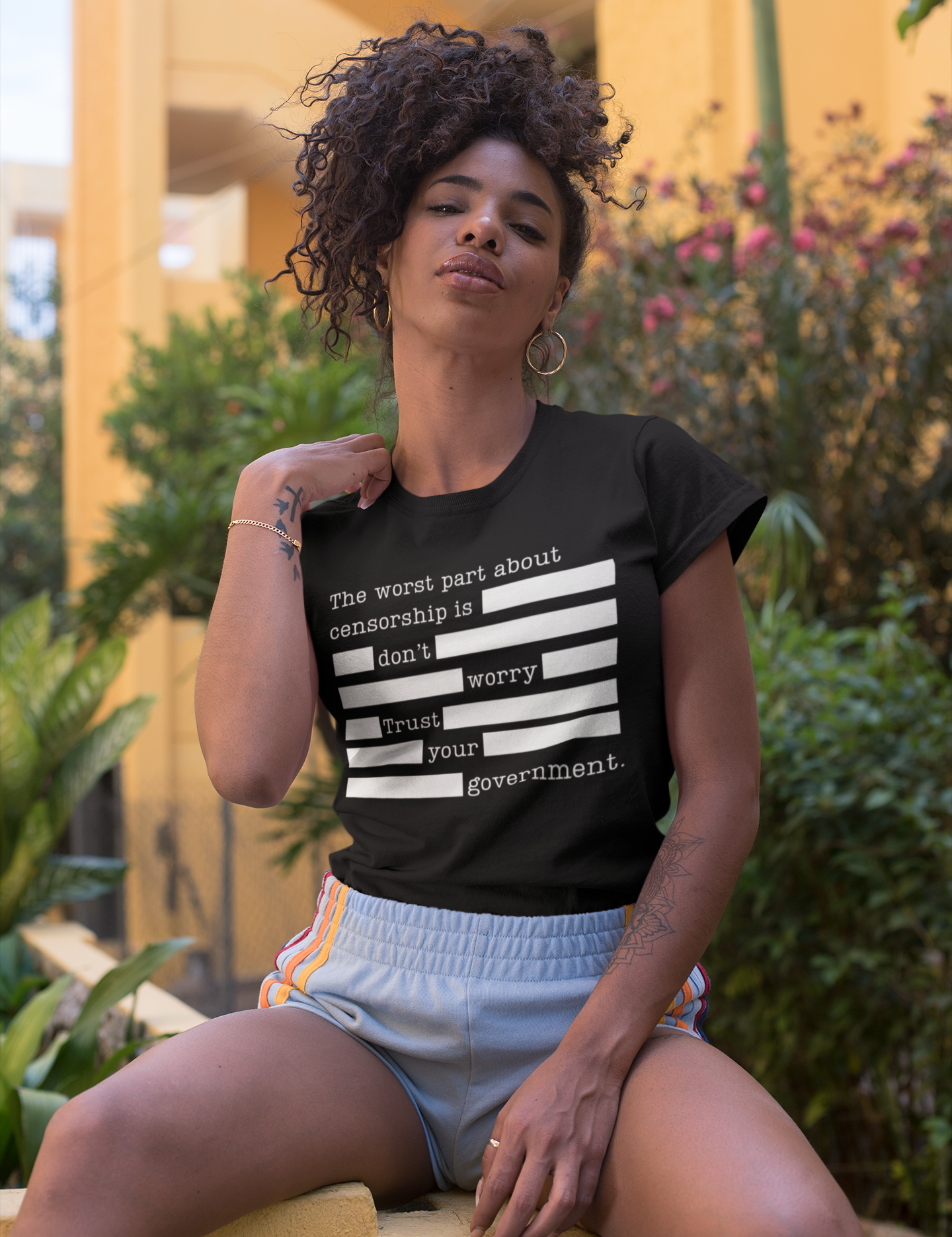 t-shirt-mockup-of-a-fierce-woman-sitting-by-a-yellow-building-27351.png