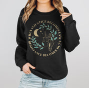 A woman wearing a black resist sweatshirt that reads "when injustice becomes law resistance becomes duty."