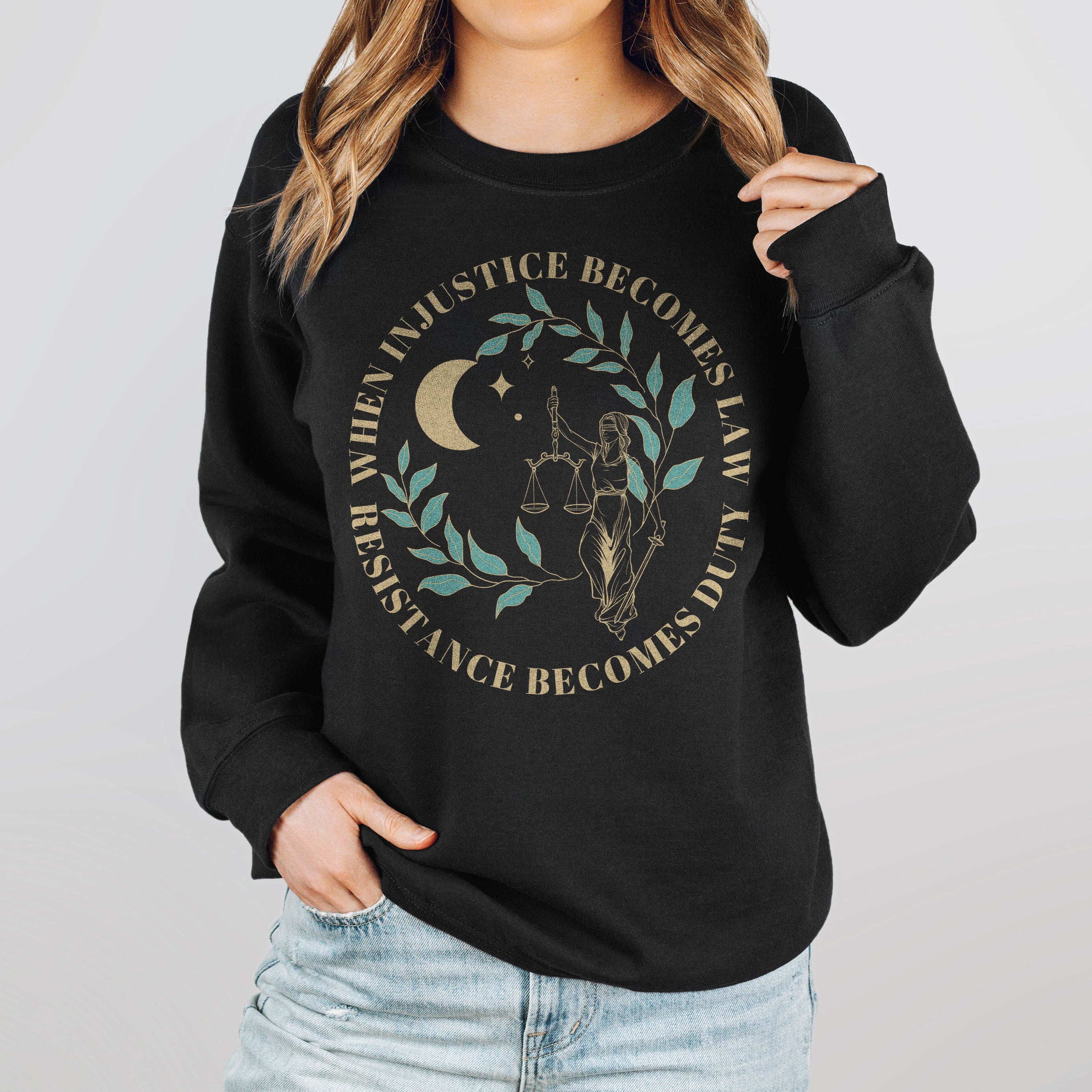 A woman wearing a black resist sweatshirt that reads "when injustice becomes law resistance becomes duty."