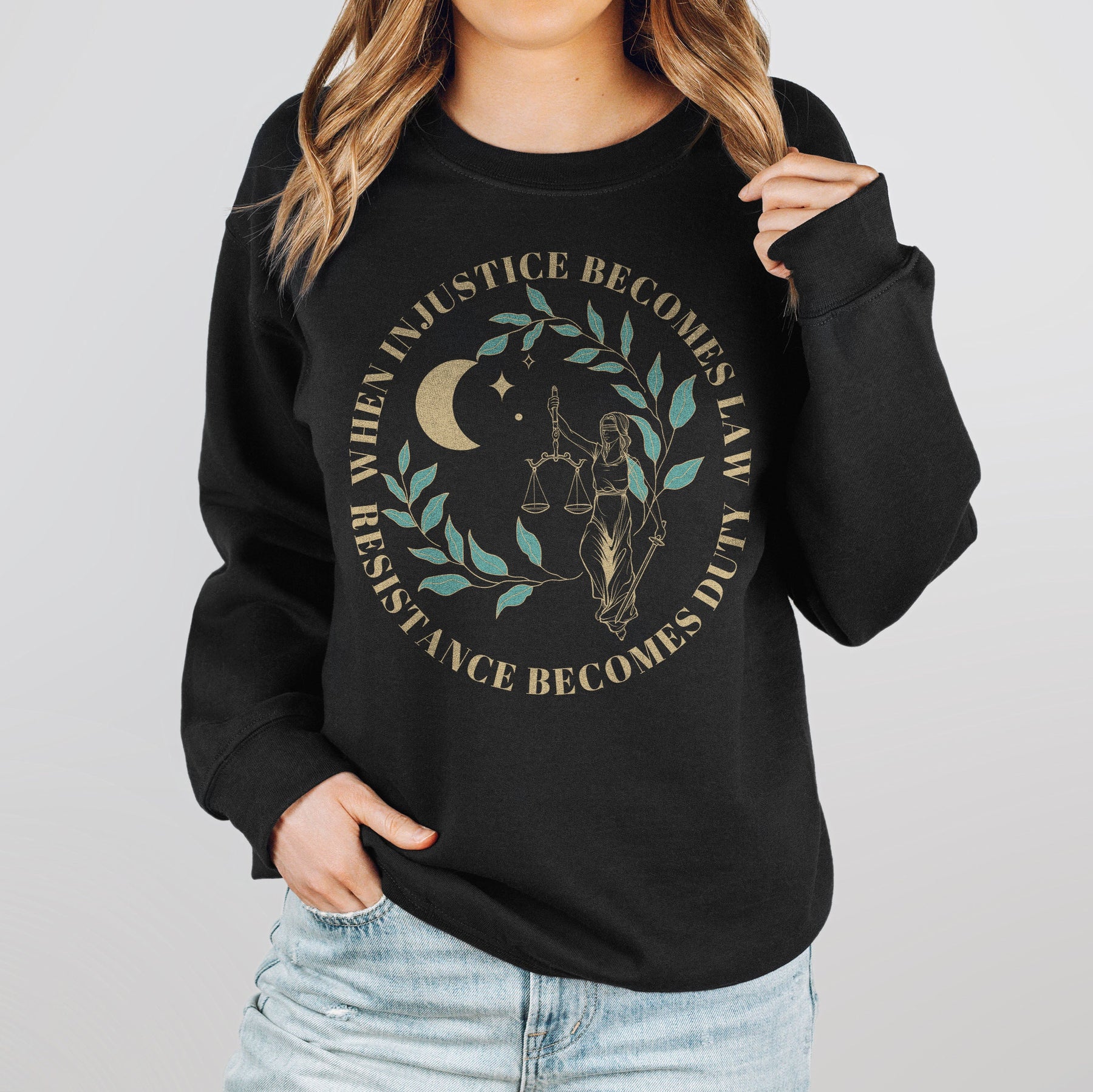 A woman wearing a black resist sweatshirt that reads "when injustice becomes law resistance becomes duty."