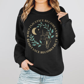 A woman wearing a black resist sweatshirt that reads "when injustice becomes law resistance becomes duty."