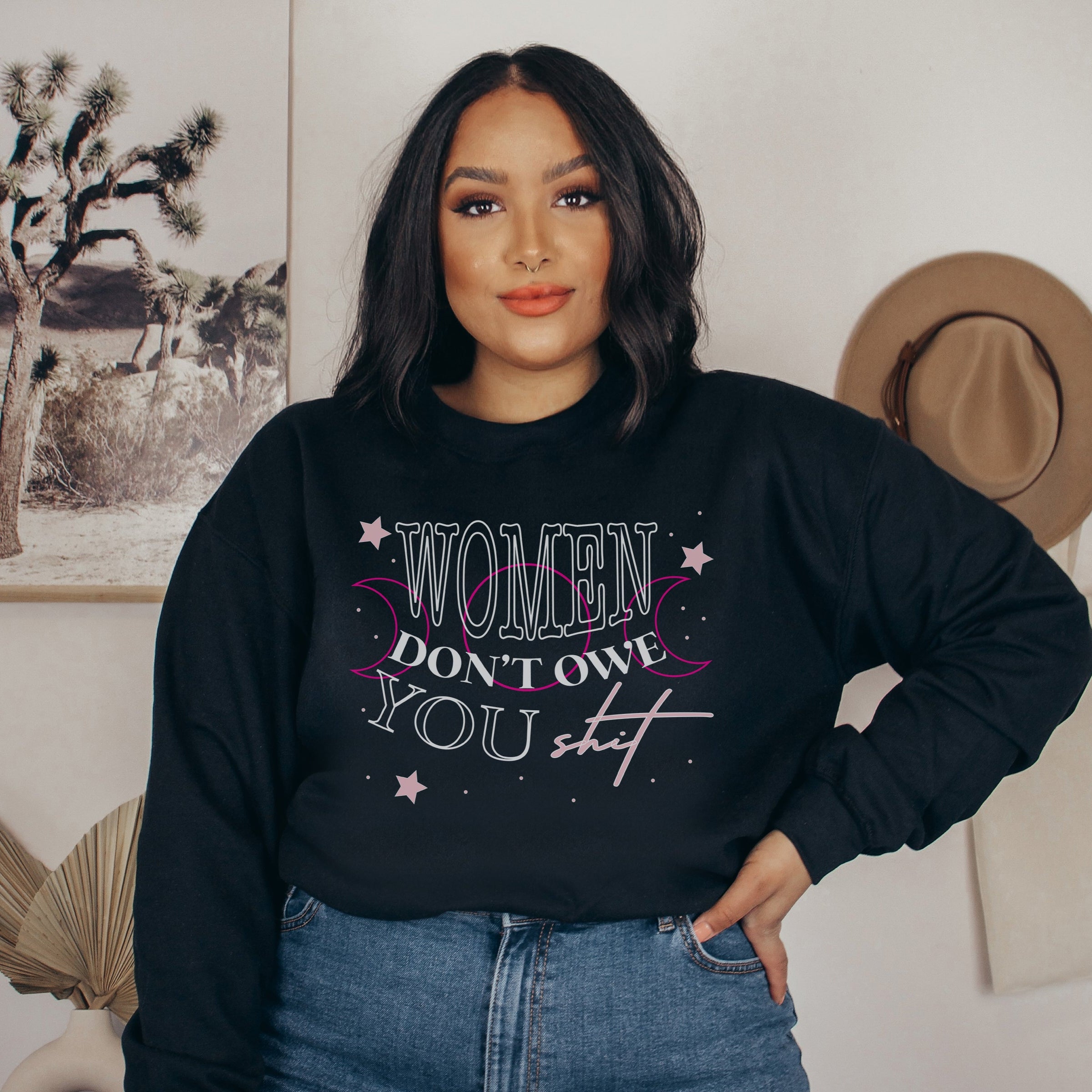 Woman wearing a sweatshirt that reads "Women don't owe you shit" 